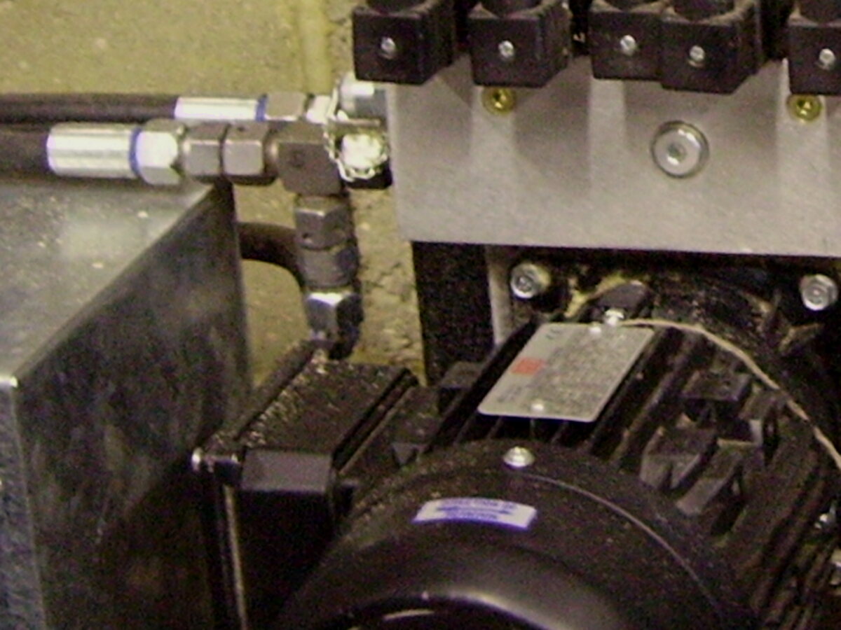 Hydraulic hose with a crimped metal fitting on a hydraulic block