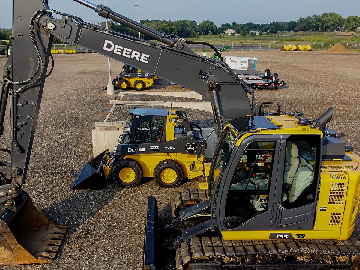 Tracked excavator and skid steer loader on a plant yard
